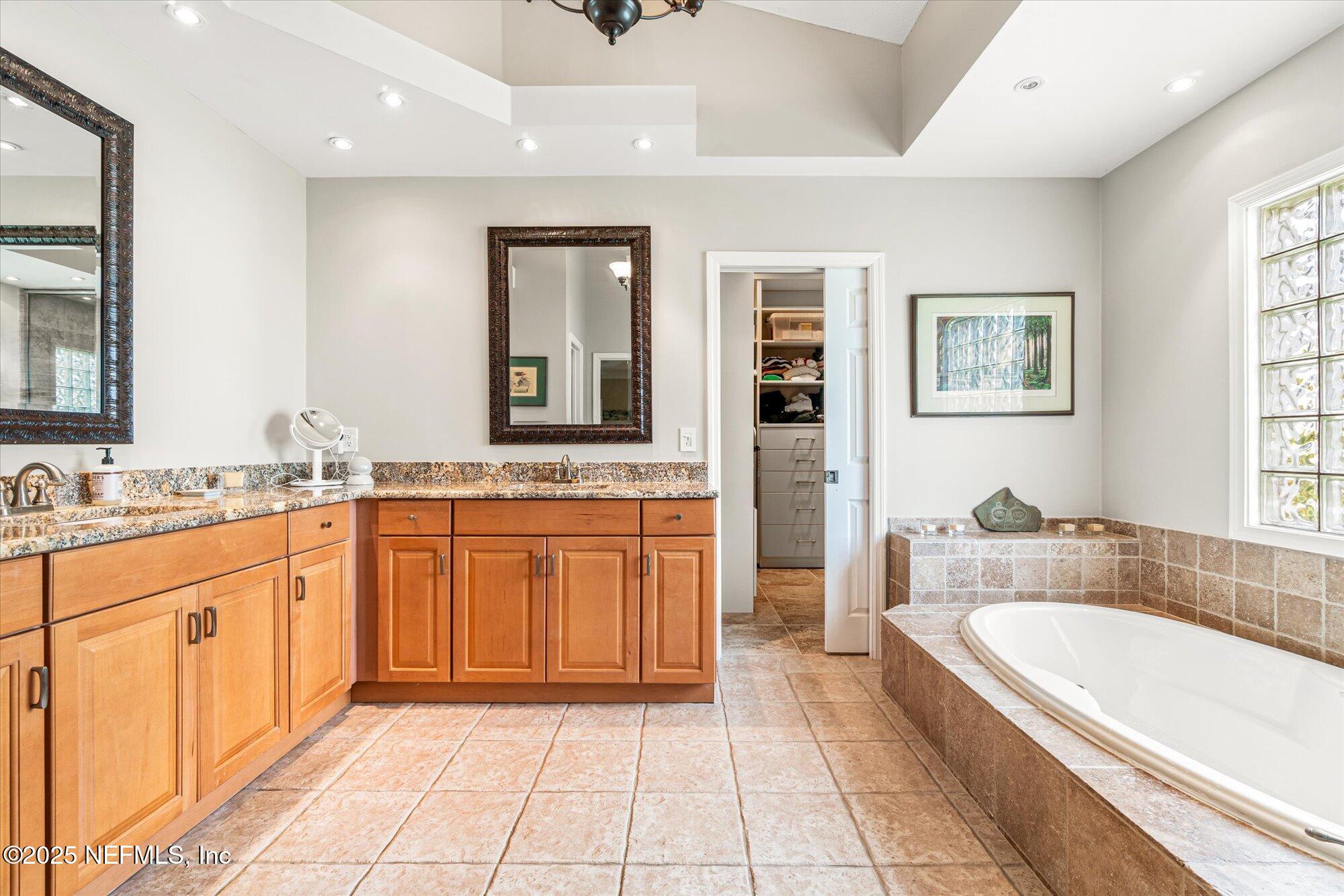 606 Teeside Court St. Augustine, FL 32080 - Photo 26 of 47 a spacious bathroom with a granite countertop tub sink and mirror