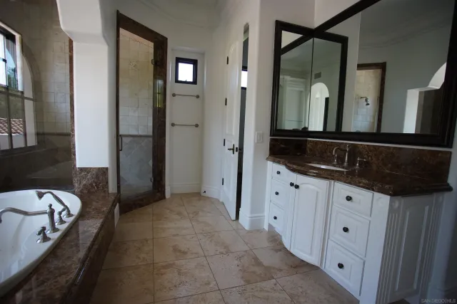 a spacious bathroom with a granite countertop tub sink and mirror