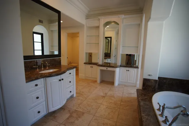 a spacious bathroom with a granite countertop sink mirror and bathtub