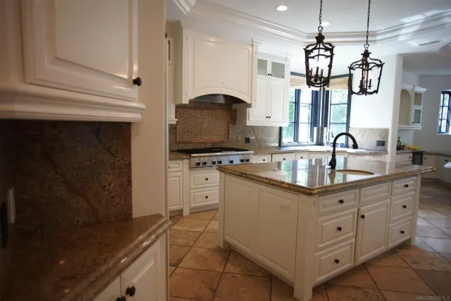 a kitchen with granite countertop a sink stainless steel appliances and cabinets