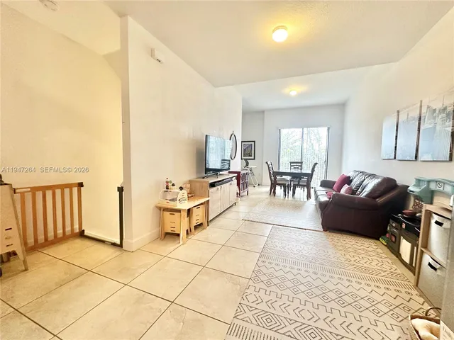 a living room with furniture and a dining table