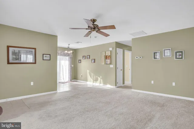 a view of a big room with a ceiling fan and windows