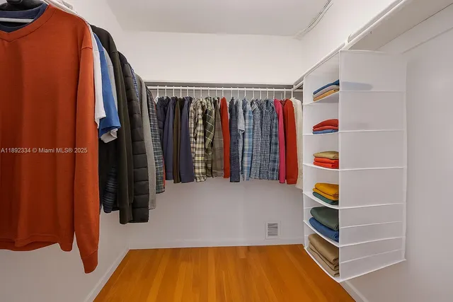 a view of walk in closet with clothes and shoes