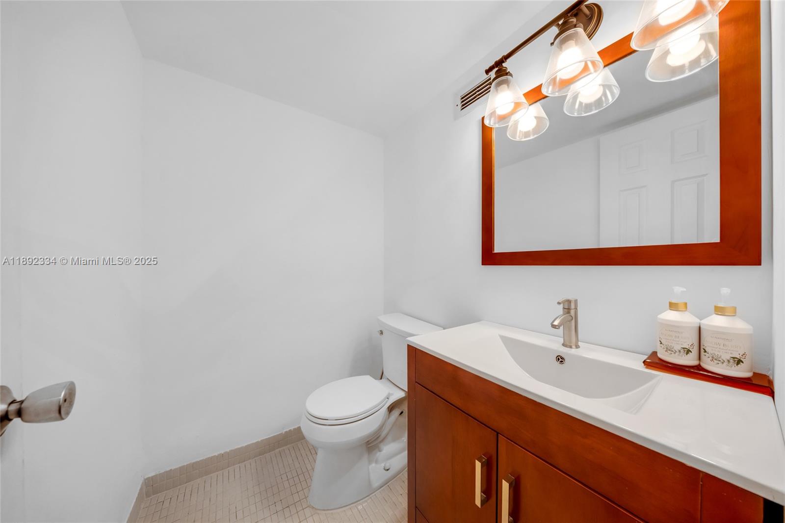 137 Golden Isles Drive, Unit 508 Hallandale Beach, FL 33009 - Photo 14 of 24 a bathroom with a sink vanity mirror and toilet