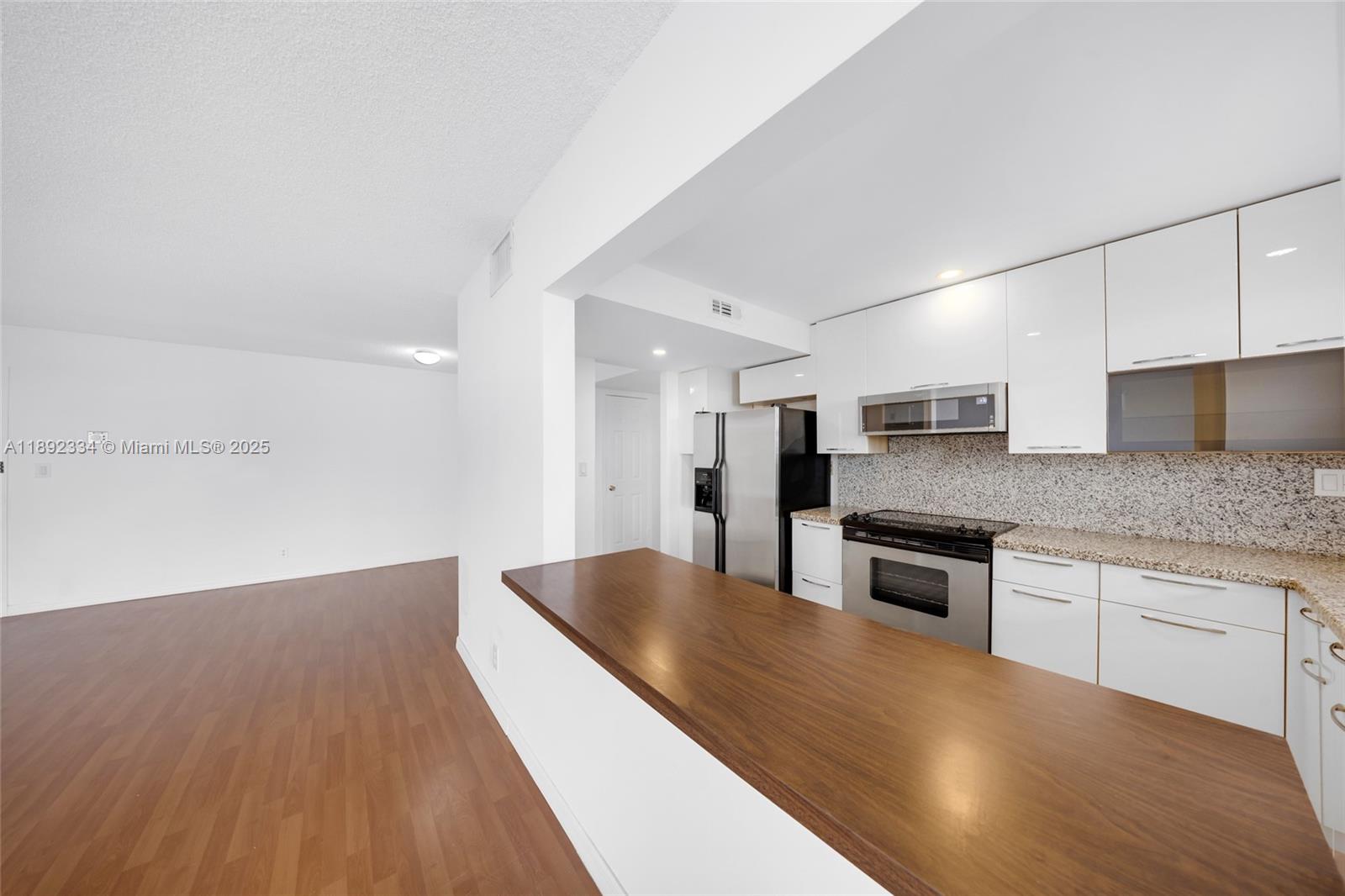 137 Golden Isles Drive, Unit 508 Hallandale Beach, FL 33009 - Photo 6 of 24 a kitchen with stainless steel appliances granite countertop a sink dishwasher stove and refrigerator