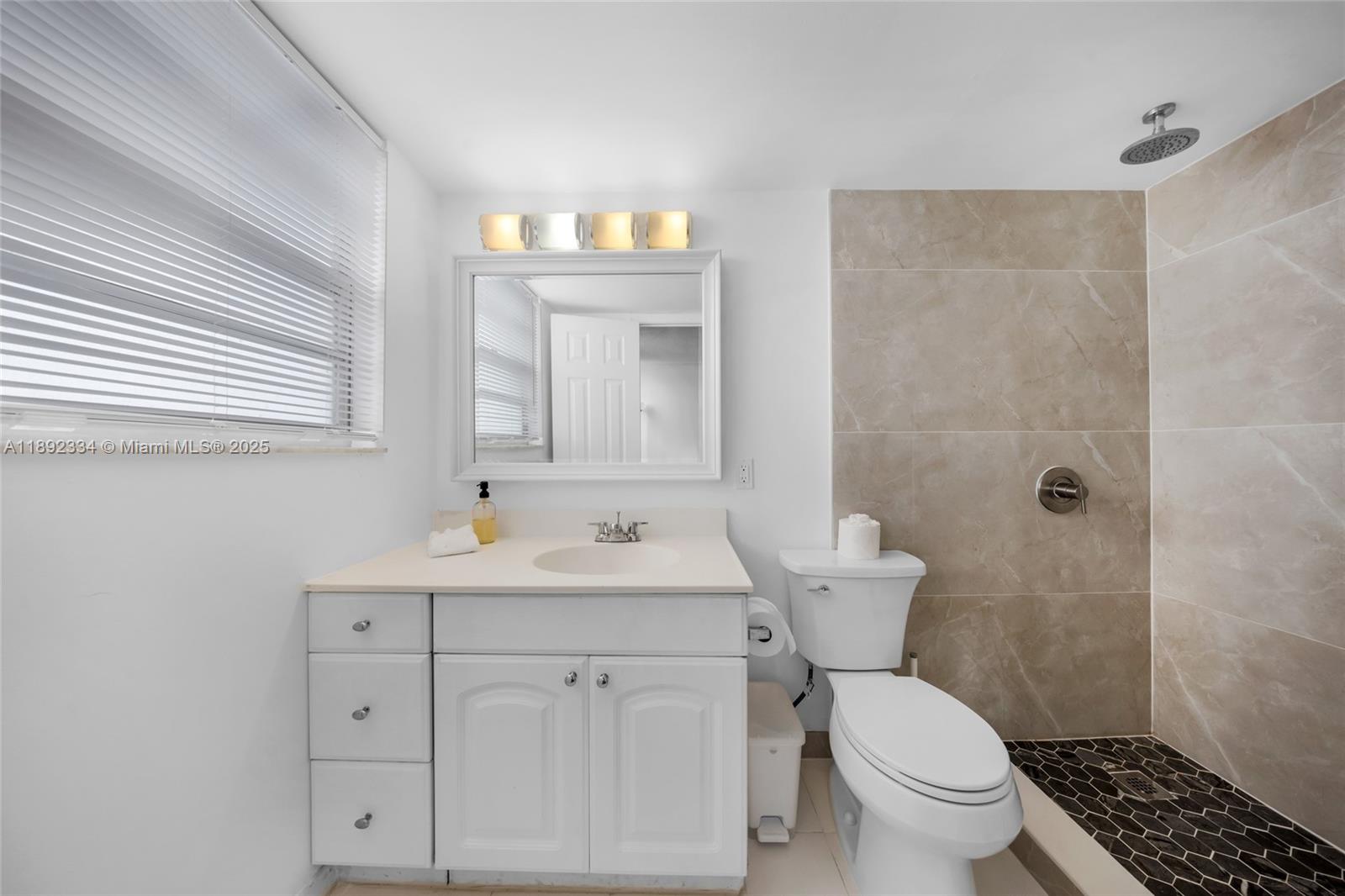 137 Golden Isles Drive, Unit 508 Hallandale Beach, FL 33009 - Photo 9 of 24 a bathroom with a toilet sink and mirror