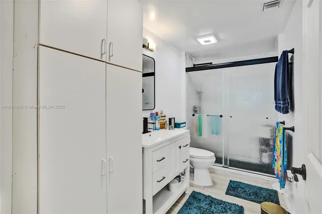 a bathroom with a sink a toilet and shower