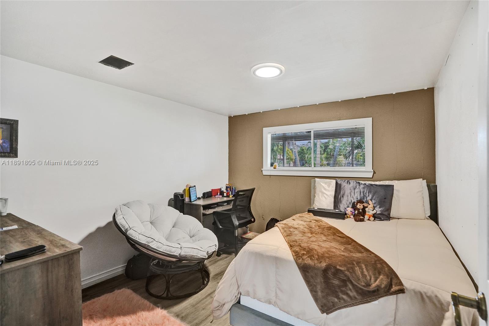 11201 Southwest 55th Street Miramar, FL 33025 - Photo 27 of 38 a bedroom with a bed and wooden floor