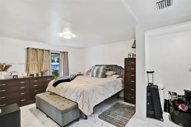 a bedroom with a bed couch and a window