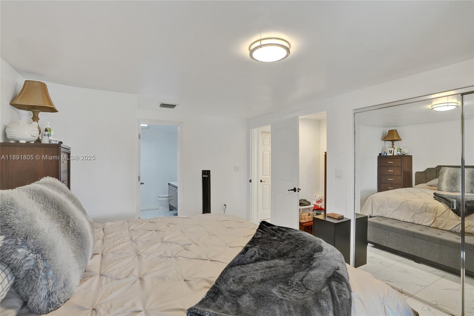 11201 Southwest 55th Street Miramar, FL 33025 - Photo 34 of 38 a bedroom with a bed and a lamp