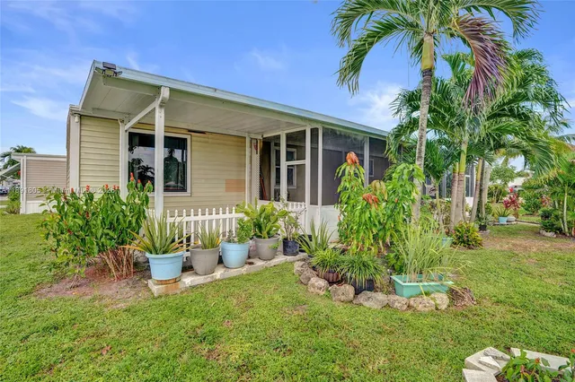 a front view of a house with a yard and potted plants