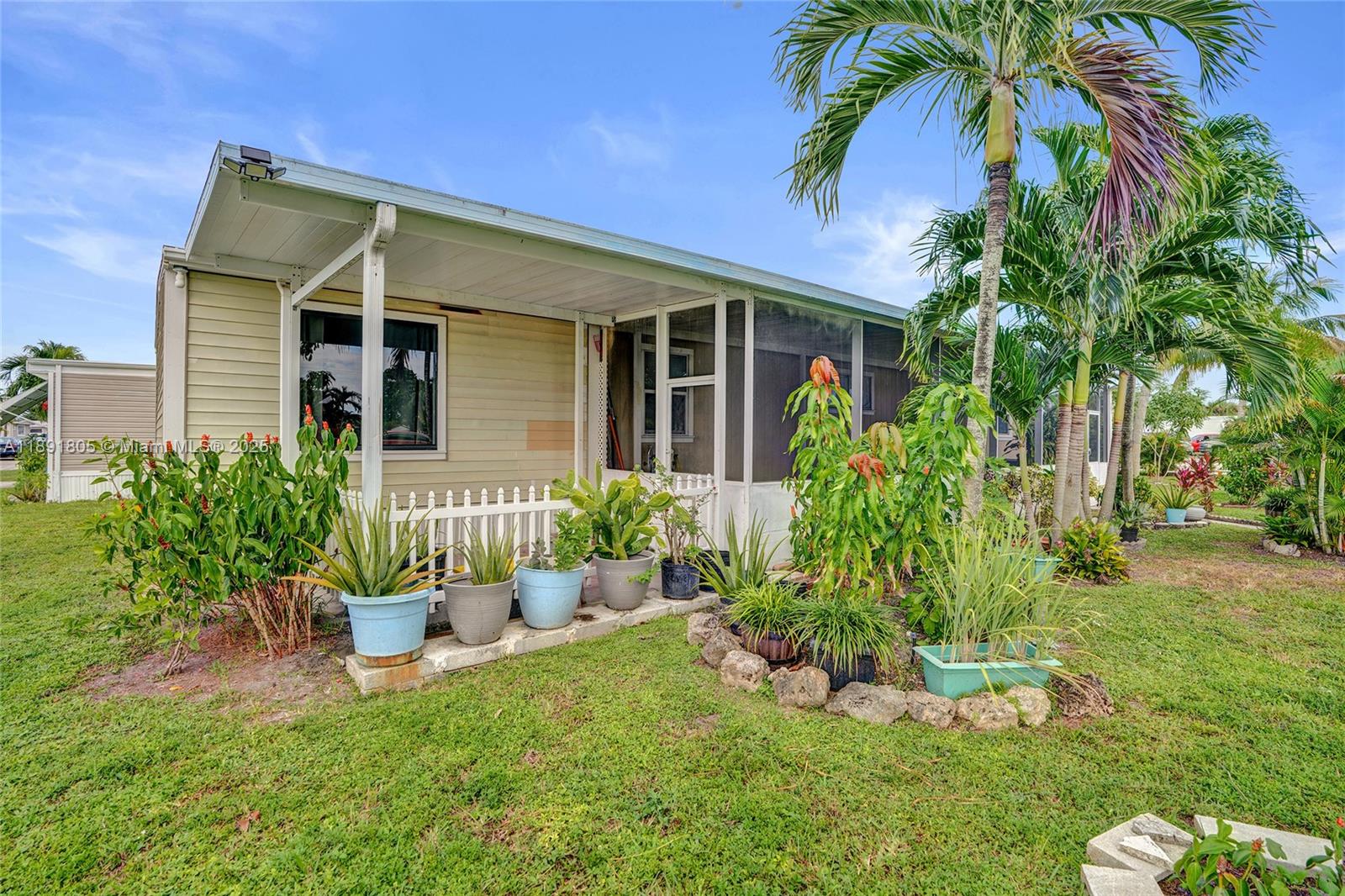 11201 Southwest 55th Street Miramar, FL 33025 - Photo 37 of 38 a front view of a house with a yard and potted plants