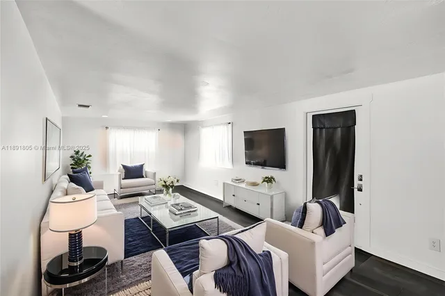 a living room with furniture a flat screen tv and a window