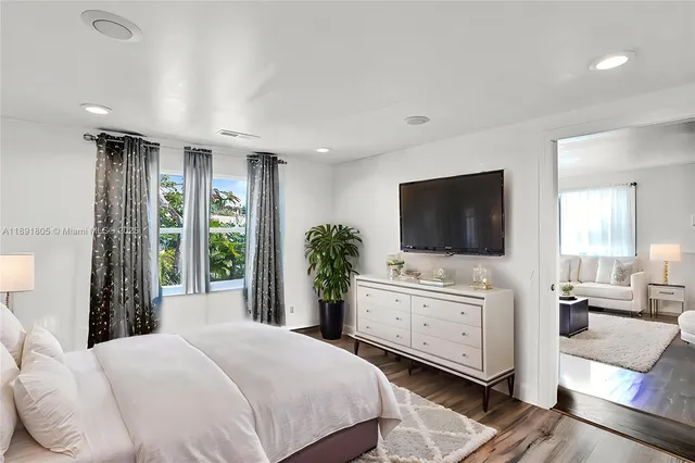 a bedroom with a large bed and a flat screen tv