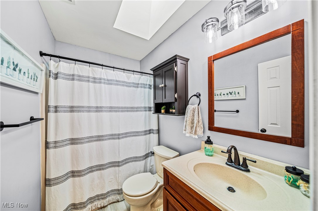 2959 Reeves Road Willoughby, OH 44094 - Photo 10 of 32 Bathroom with a skylight, vanity, a shower with curtain, and toilet