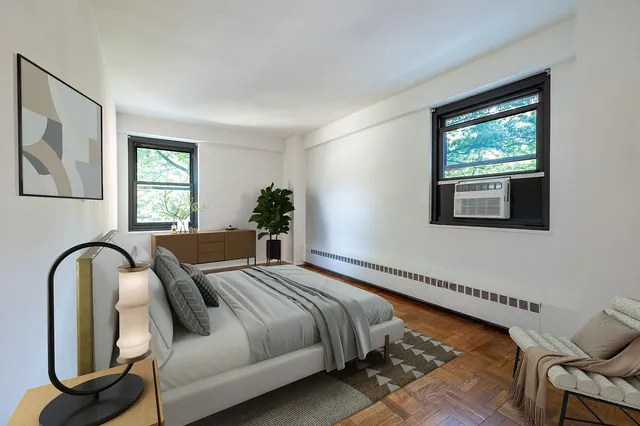 a view of an empty room with a window and wooden floor