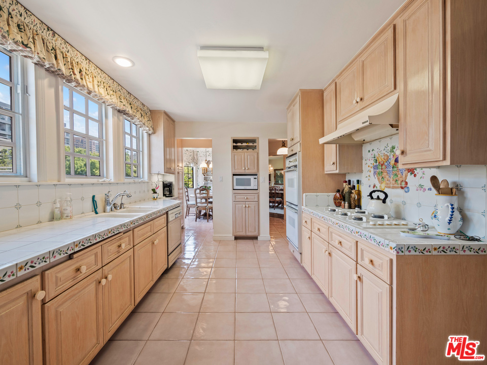 810 Devon Avenue Los Angeles, CA 90024 - Photo 6 of 23 a large kitchen with stainless steel appliances granite countertop a sink and cabinets
