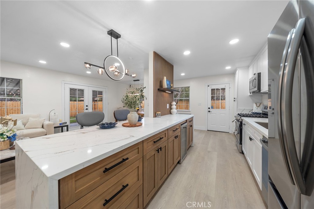 2717 West 6th Street Rialto, CA 92376 - Photo 5 of 30 a kitchen with stainless steel appliances kitchen island granite countertop a sink and dishwasher