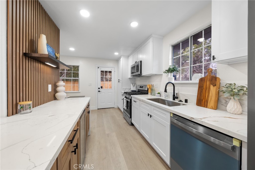 2717 West 6th Street Rialto, CA 92376 - Photo 6 of 30 a kitchen with a sink stove and cabinets