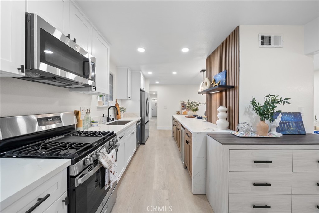 2717 West 6th Street Rialto, CA 92376 - Photo 8 of 30 a kitchen with stainless steel appliances a sink stove and cabinets