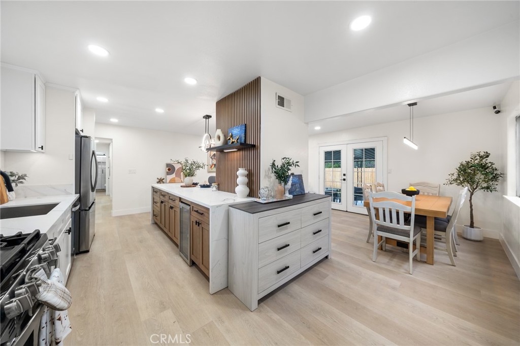 2717 West 6th Street Rialto, CA 92376 - Photo 9 of 30 a kitchen with kitchen island white cabinets and wooden floor
