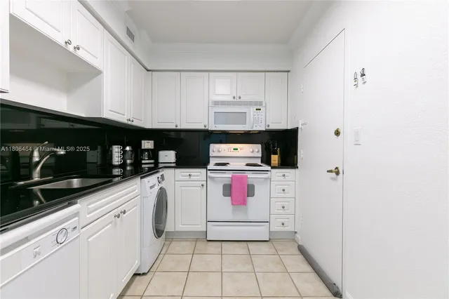 a kitchen with stainless steel appliances a white stove top oven and white cabinets