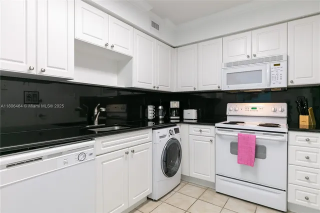 a kitchen with granite countertop cabinets and white appliances