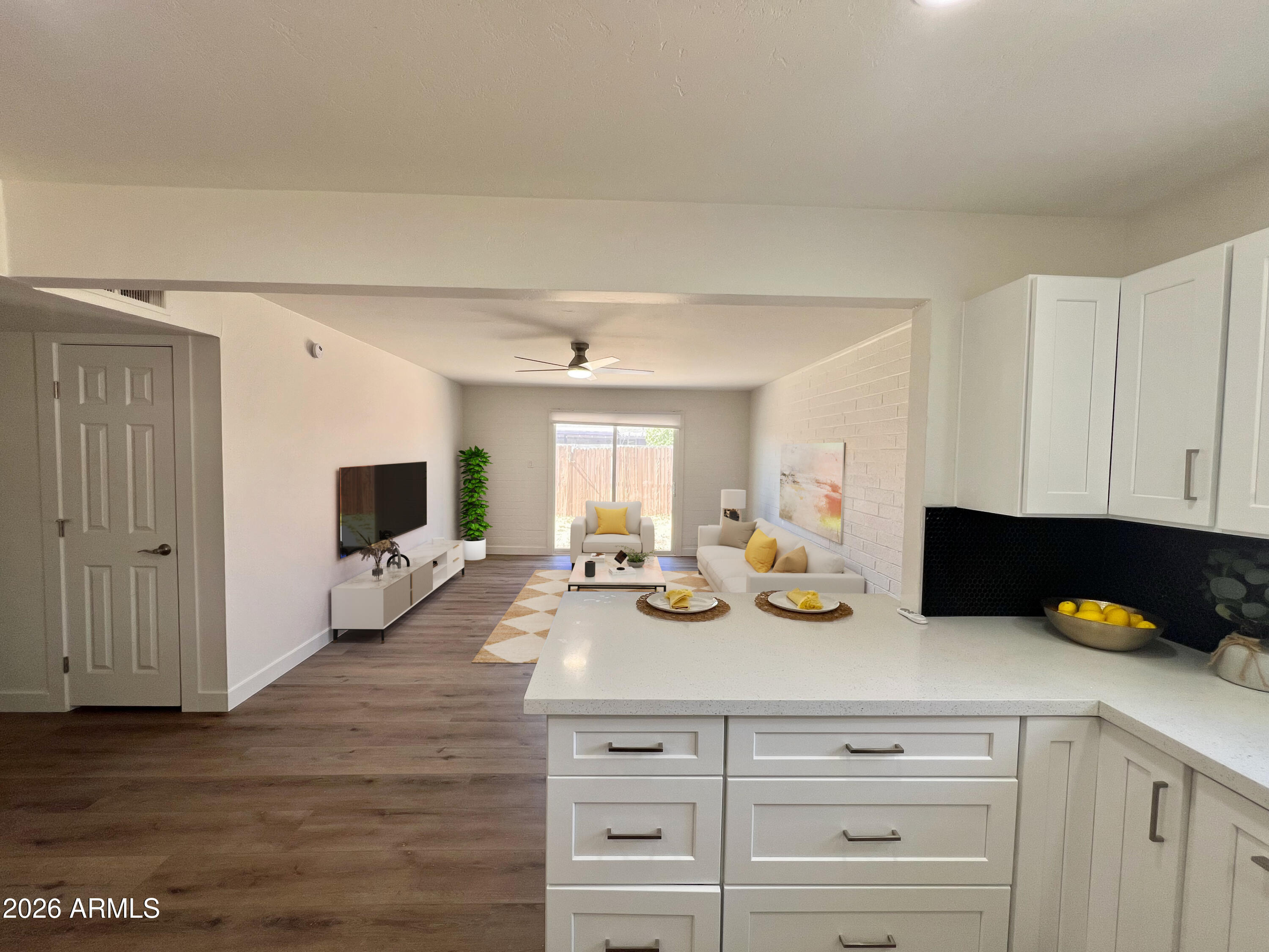 3818 West Ruth Avenue Phoenix, AZ 85051 - Photo 5 of 20 a kitchen with a sink dishwasher stove and white cabinets with wooden floor