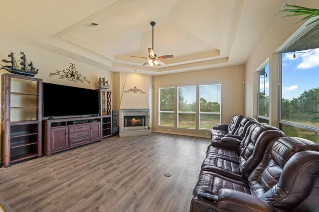 a living room with furniture a flat screen tv and a large window