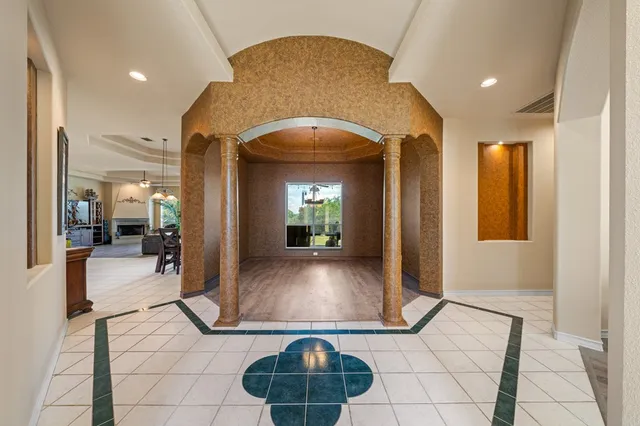 a view of a hallway with dining area and chandelier