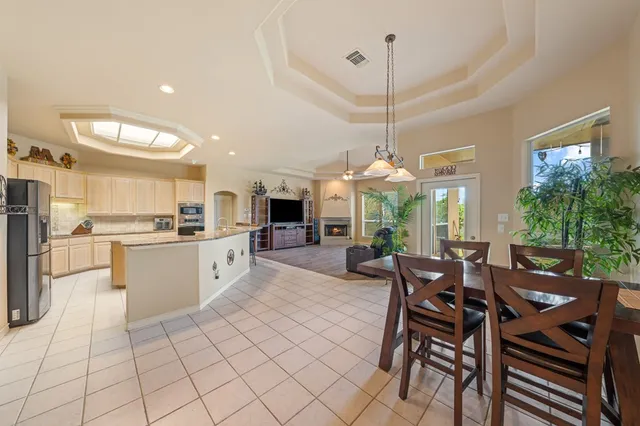 a kitchen with stainless steel appliances kitchen island granite countertop a sink table and chairs in it