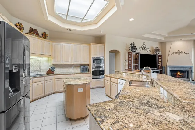 a kitchen with stainless steel appliances granite countertop a sink dishwasher stove refrigerator and cabinets