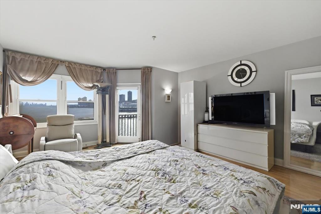 214 The Promenade, Unit 214 Edgewater, NJ 07020 - Photo 19 of 36 a bedroom with a bed and a television