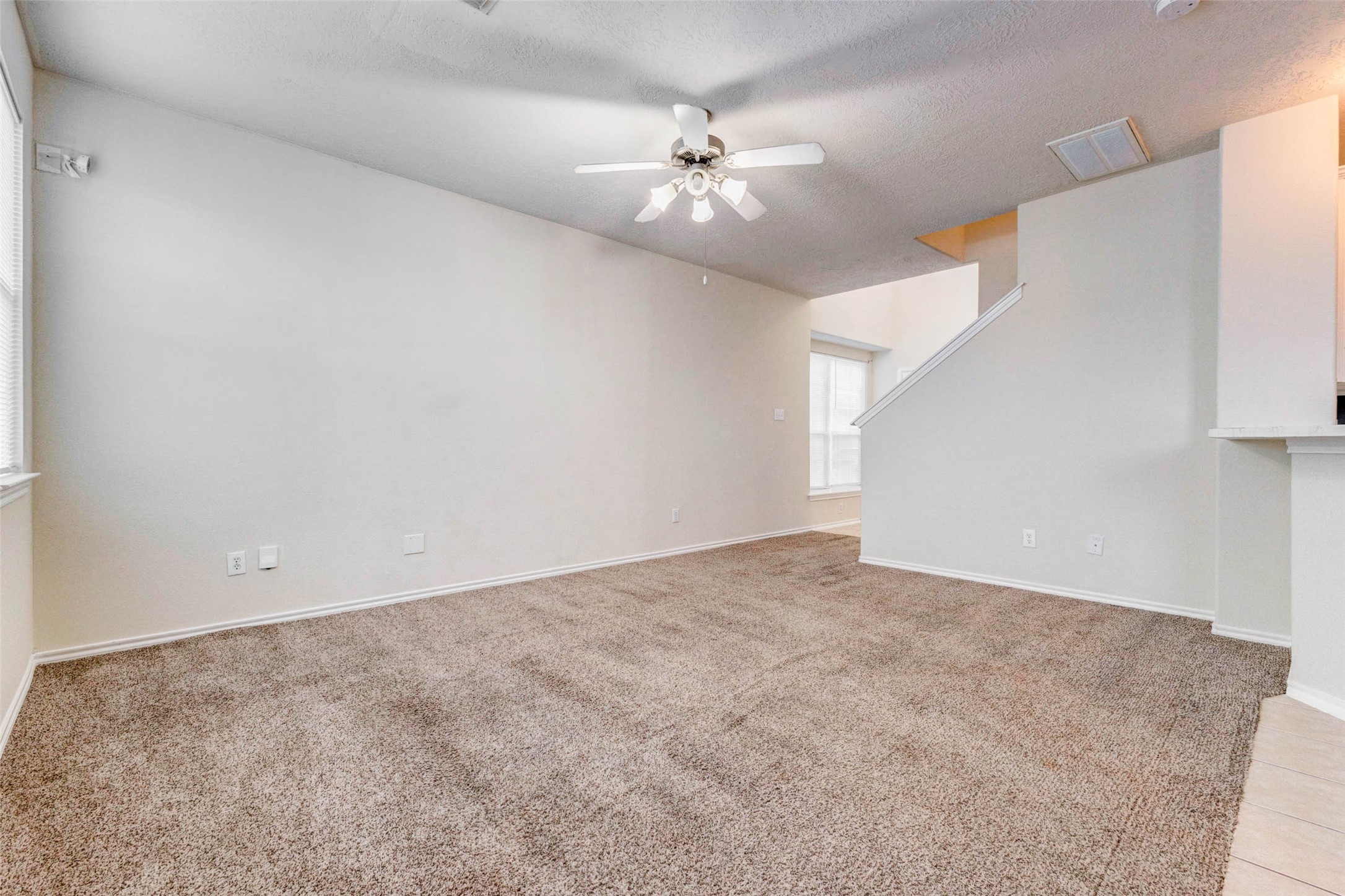 13106 Peppergate Lane Houston, TX 77044 - Photo 3 of 17 an empty room with a chandelier fan and windows