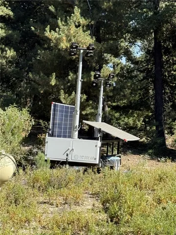 a view of a house with large trees and a small yard