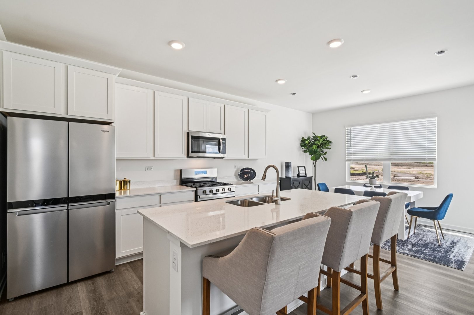 2461 Semillon Street Oswego, IL 60543 - Photo 14 of 45 a kitchen with stainless steel appliances granite countertop a dining table chairs refrigerator and cabinets