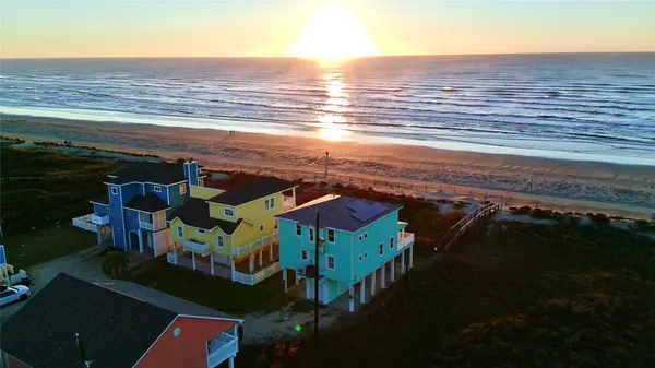 an aerial view of residential houses with outdoor space and ocean view