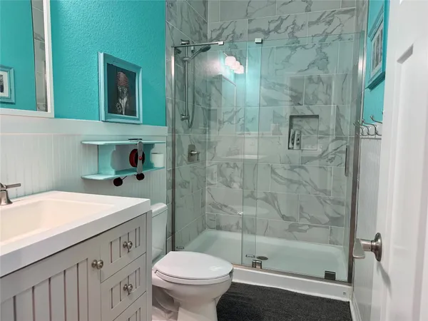 a bathroom with a sink toilet a mirror and shower
