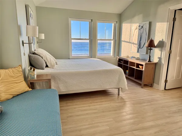 a bedroom with a bed wooden floor and window