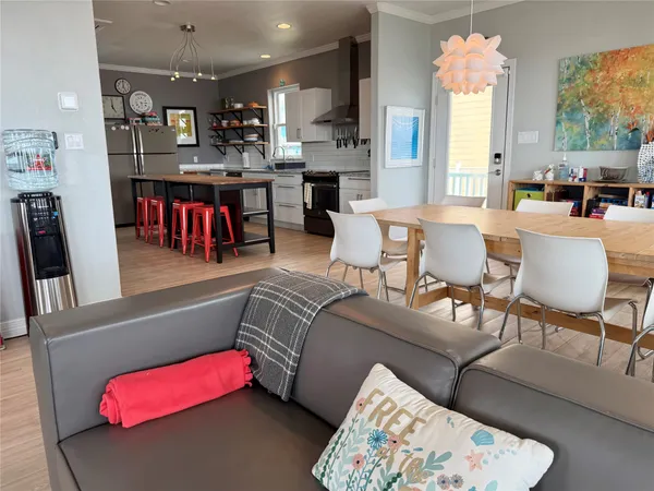 a living room with furniture kitchen view and a large window