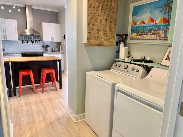 a view of washer and dryer with kitchen in the background