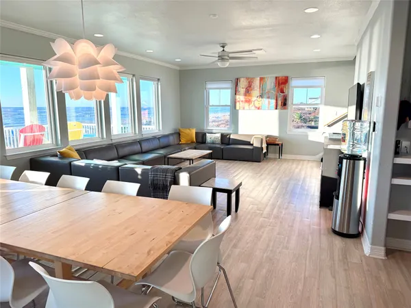 a large living room with stainless steel appliances furniture a fireplace and a large window