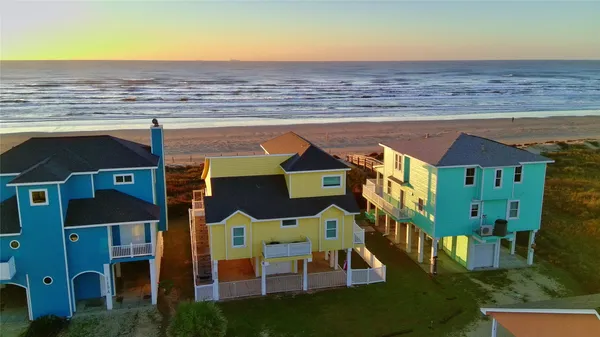 an aerial view of residential houses with outdoor space and ocean view