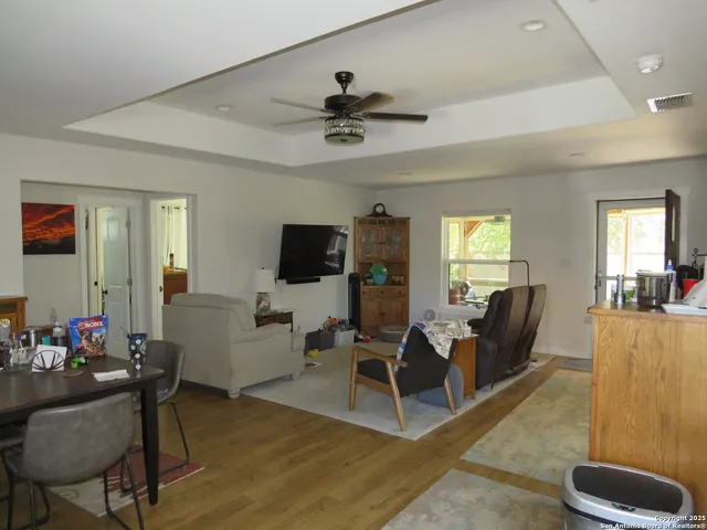 a living room with furniture a flat screen tv and a window