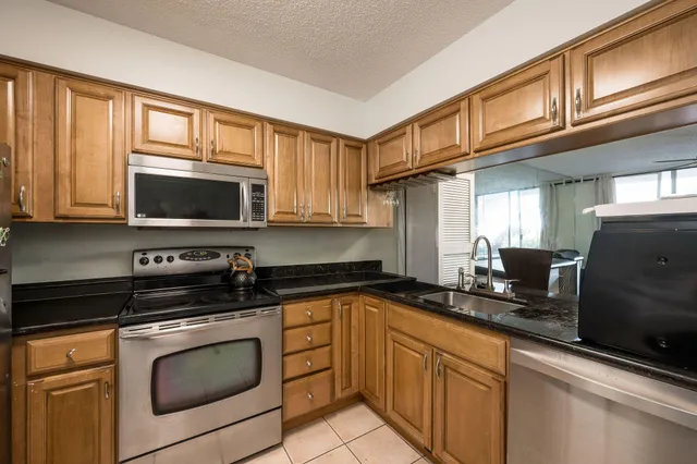 a kitchen with stainless steel appliances granite countertop a sink stove and cabinets