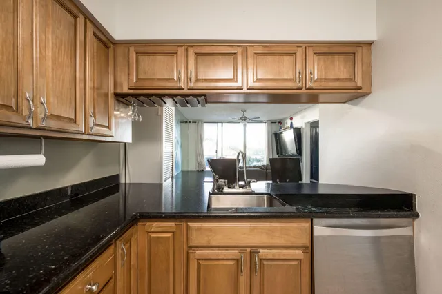 a kitchen with stainless steel appliances granite countertop a stove a washer and a sink