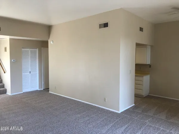 an empty room with an entryway and fan