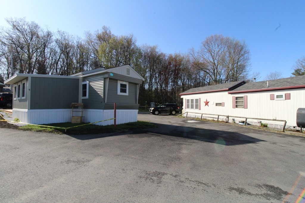 11 Groton School Road, Unit 4 Ayer, MA 01432 - Photo 11 of 11 a front view of a house with a yard and garage