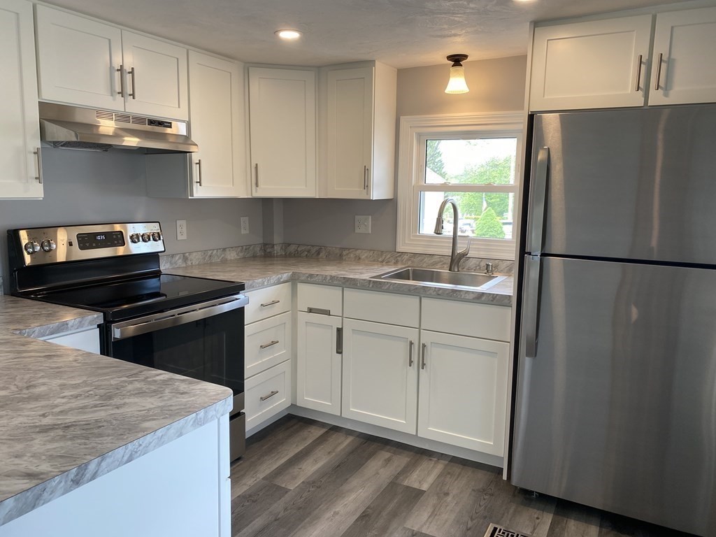 11 Groton School Road, Unit 4 Ayer, MA 01432 - Photo 3 of 11 a kitchen with a white cabinets and white appliances