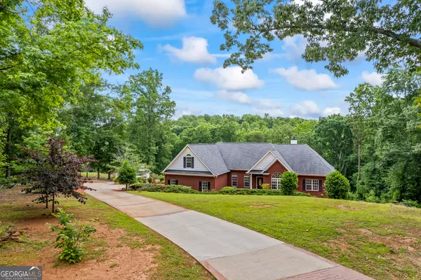 a front view of house with yard and trees in the background